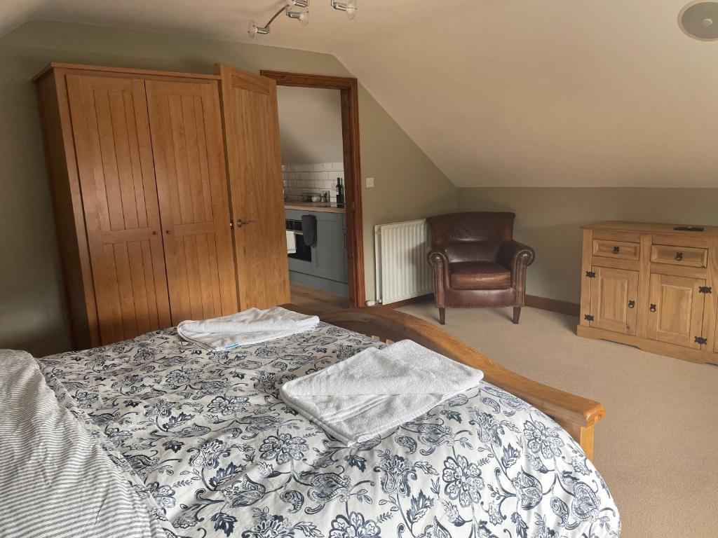 a bedroom with a bed and a chair at Fabulous 2 Bed Apartment in Penrith