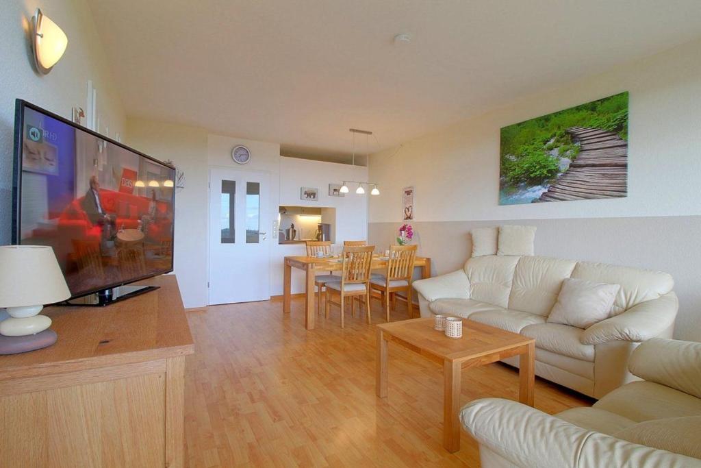 ein Wohnzimmer mit einem Sofa und einem Flachbild-TV in der Unterkunft Apartment 535 in Hohegeiß