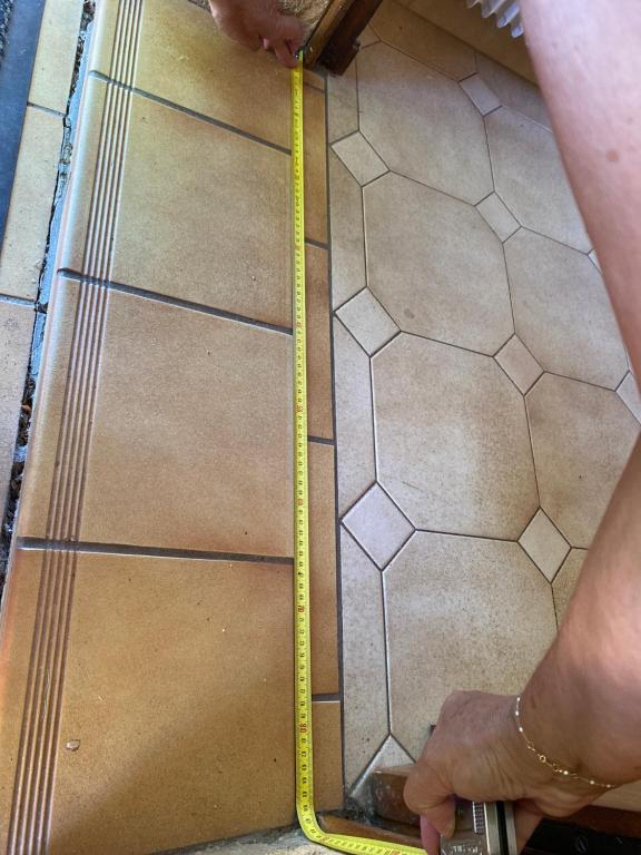 a person holding a yellow tape on a tiled floor at Claire fontaine in Beaumont-du-Périgord