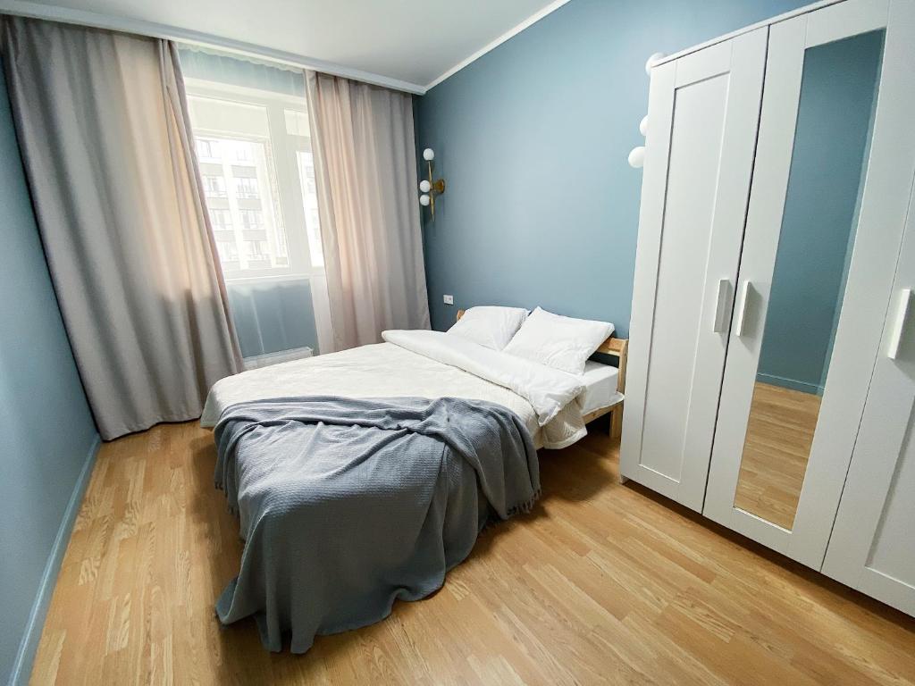 - une petite chambre avec un lit et une fenêtre dans l'établissement Апартаменты у Триумфальной арки, à Astana