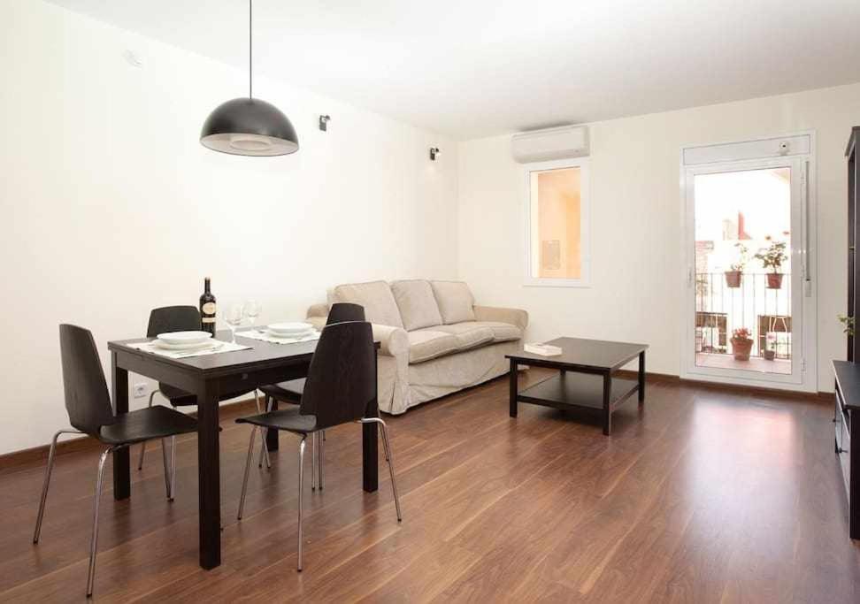 een woonkamer met een tafel en een bank bij Apart céntrico con terraza en Gracia in Barcelona