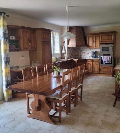 a kitchen with a large wooden table and chairs at Claire fontaine in Beaumont-du-Périgord