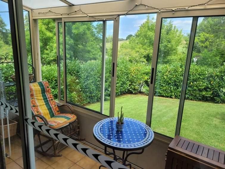 a screened in porch with a table and a chair at Claire fontaine in Beaumont-du-Périgord