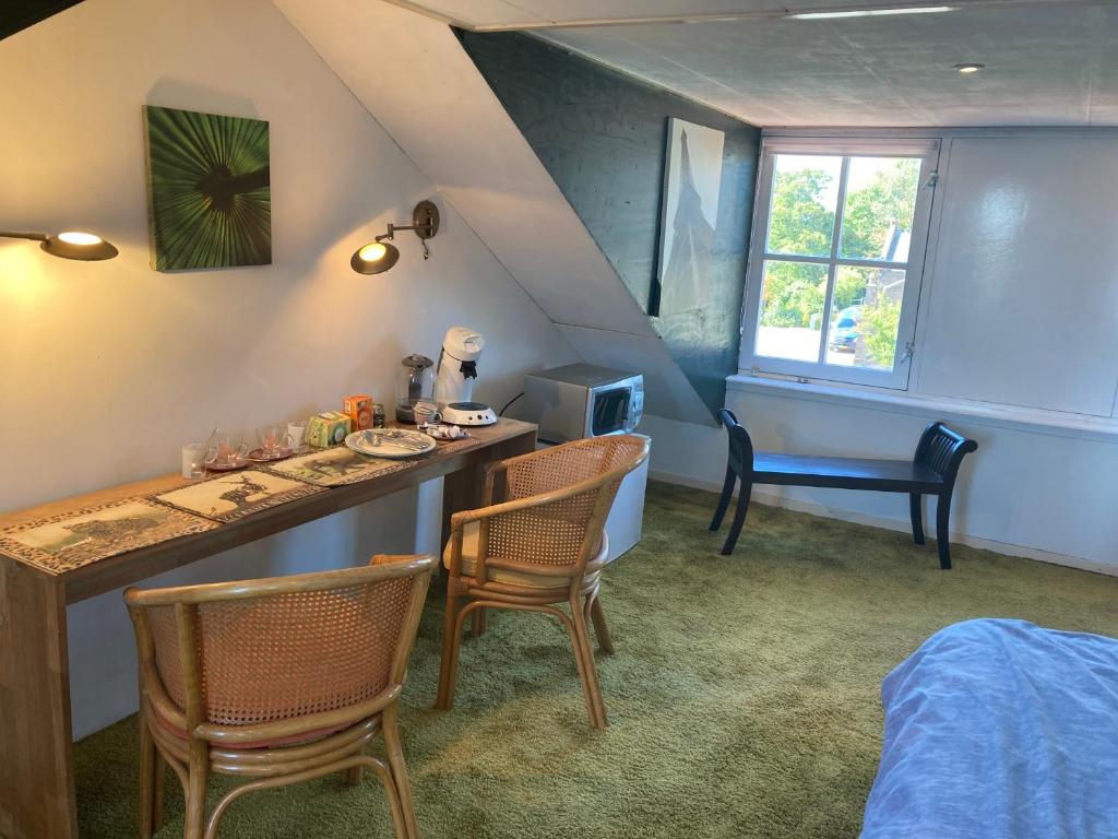 Cette chambre comprend une table, des chaises et un lit. dans l'établissement Luc's place, Waterbed grote kamer, à Zoeterwoude