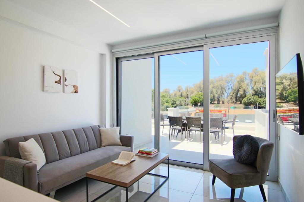 a living room with a couch and a table at Phaedrus Living - Seaside Deluxe Flat Harbour 112 in Paphos