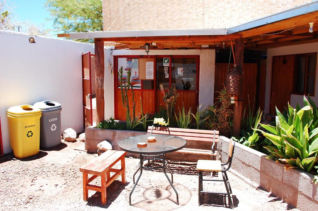 patio ze stołem i ławką oraz budynek w obiekcie Hostal Miskanty w mieście San Pedro de Atacama