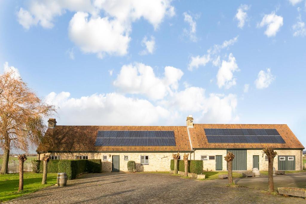 een huis met zonnepanelen op het dak bij Villa 't Korenhof - Landelijk gelegen villa op 4 km van het strand in Koksijde