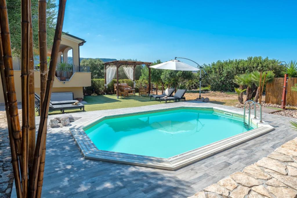 une piscine dans une cour avec une maison dans l'établissement Villa Pedra Alghero - appartamento in villa con piscina, à Alghero