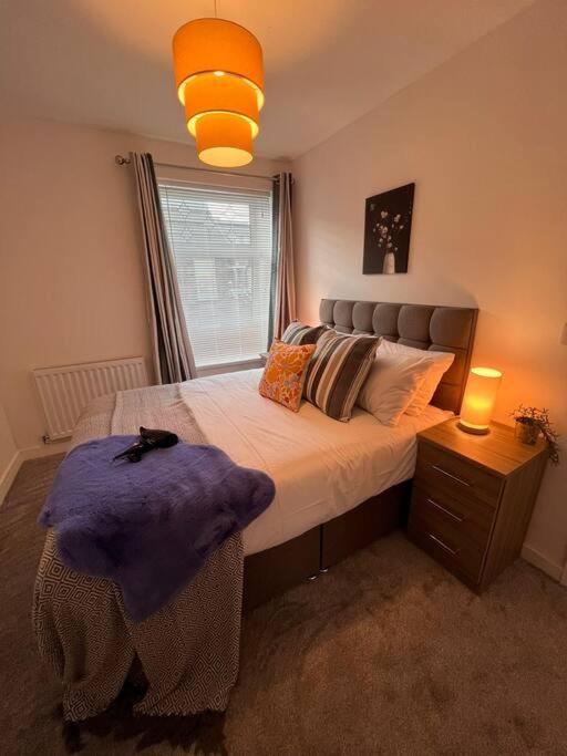 a bedroom with a large bed with a purple blanket at Stay at The Penn! 5 Bedroomed home in Treharris in Treharris