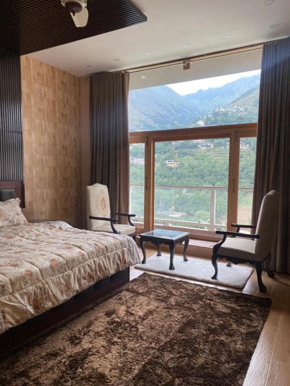 a bedroom with a bed and a large window at The Swat House in Swat