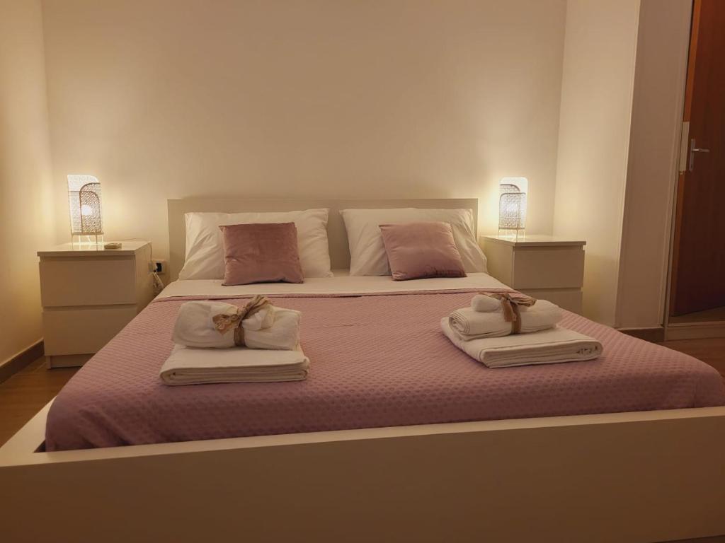 1 dormitorio con 1 cama grande y 2 toallas en La Perla Di Noto, en Noto