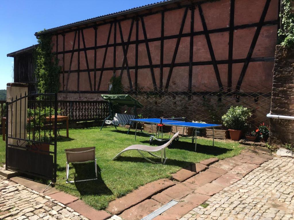 un jardín con una mesa y un columpio en Au Relais de l'Histoire Gîte classé 4 étoiles, en Oberbronn