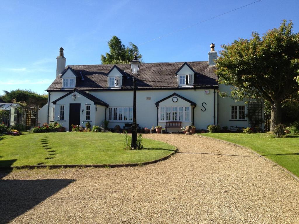 a large white house with a gravel driveway at Hungarton Bed & Breakfast in Hungerton