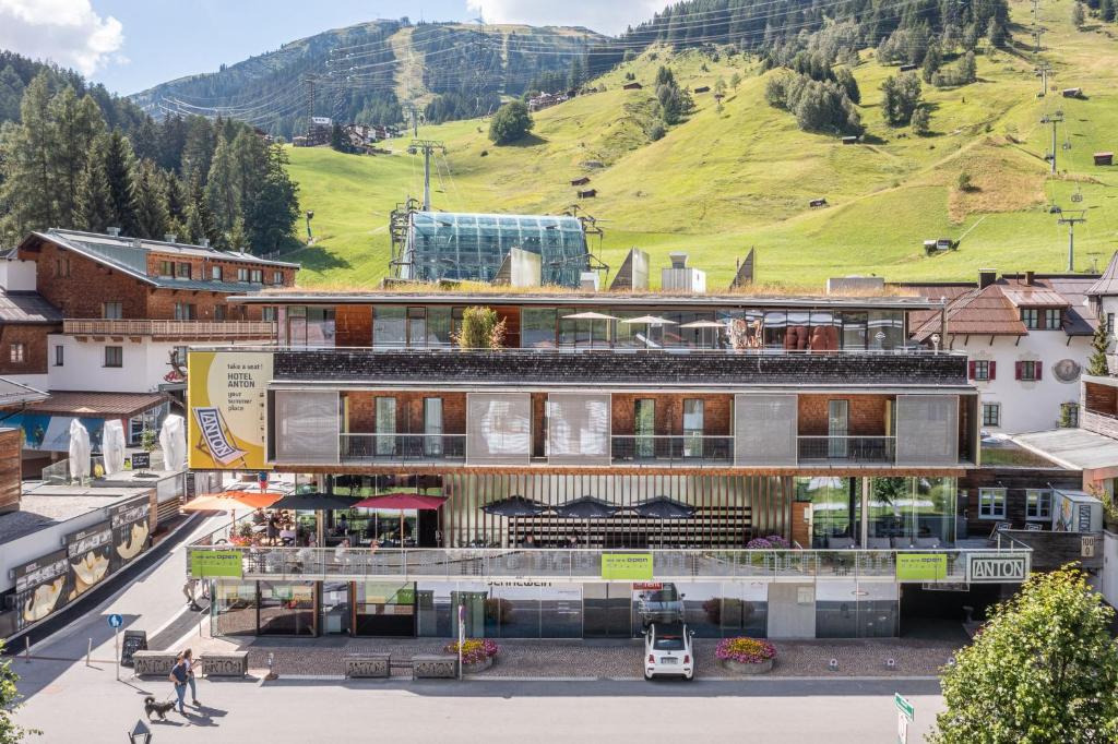 a building in a town with a mountain in the background at Quality Hosts Arlberg - Hotel ANTON in Sankt Anton am Arlberg