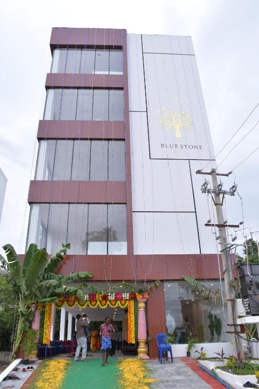 a building with people standing in front of it at Hotel Bluestone in Srikalahasti