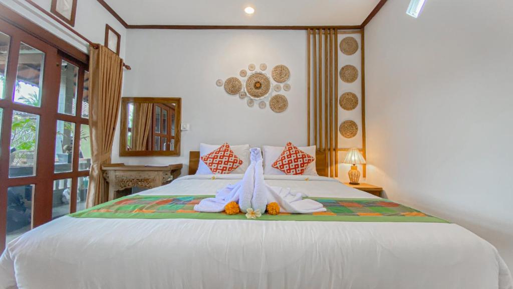 a bedroom with a bed with towels on it at Raditya House in Ubud