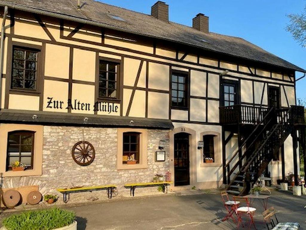 ein altes Steingebäude mit einer Treppe davor in der Unterkunft Alte Mühle Börfink in Börfink