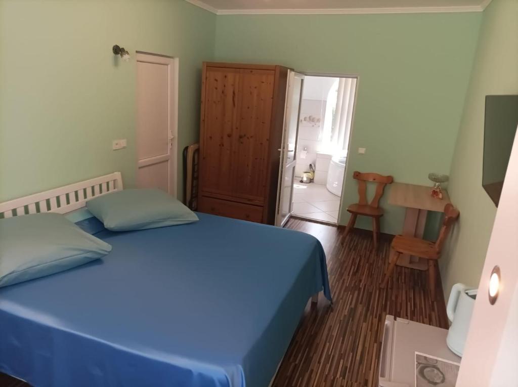 a bedroom with a blue bed and a bathroom at Casa Victoria Anina in Anina