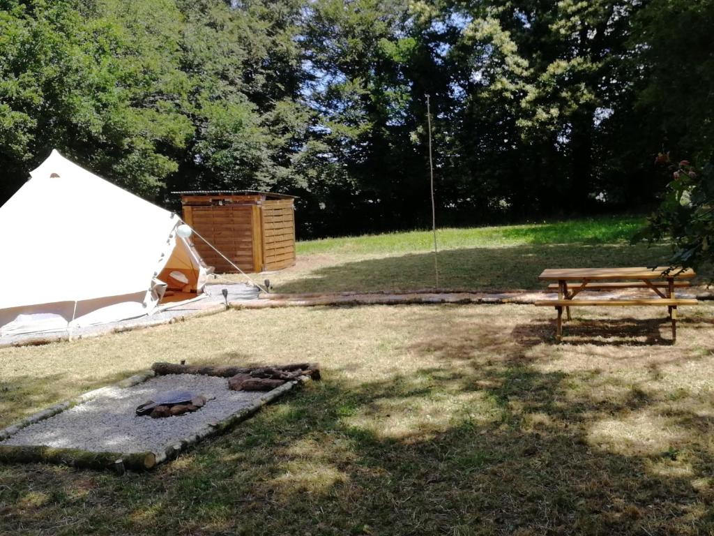 una tienda y una mesa de picnic en un campo en tente insolite 1 à 5 personnes, en Plouray