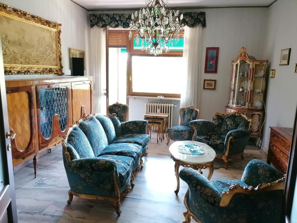 a living room with couches and a table and a chandelier at Alloggio Margherita in Turin