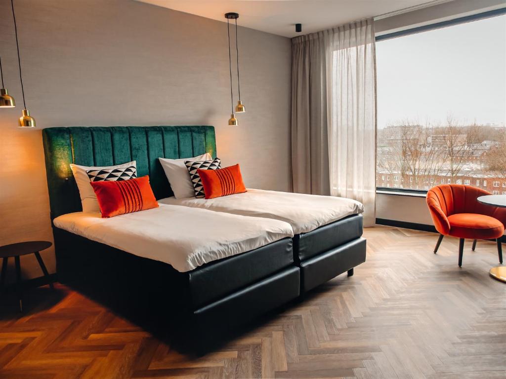 een slaapkamer met een bed en een groot raam bij Van der Valk Hotel Schiedam in Schiedam