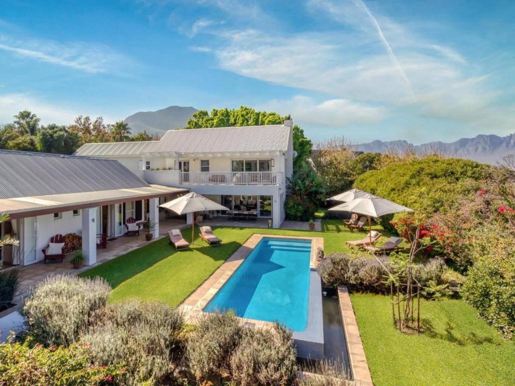 an aerial view of a house with a pool and yard at Explorer Guesthouse in Somerset West