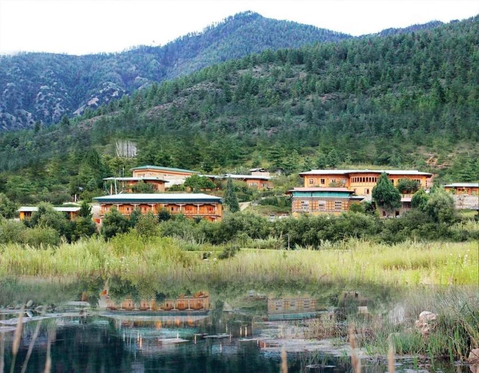 a group of buildings next to a body of water at Rema Resort in Paro