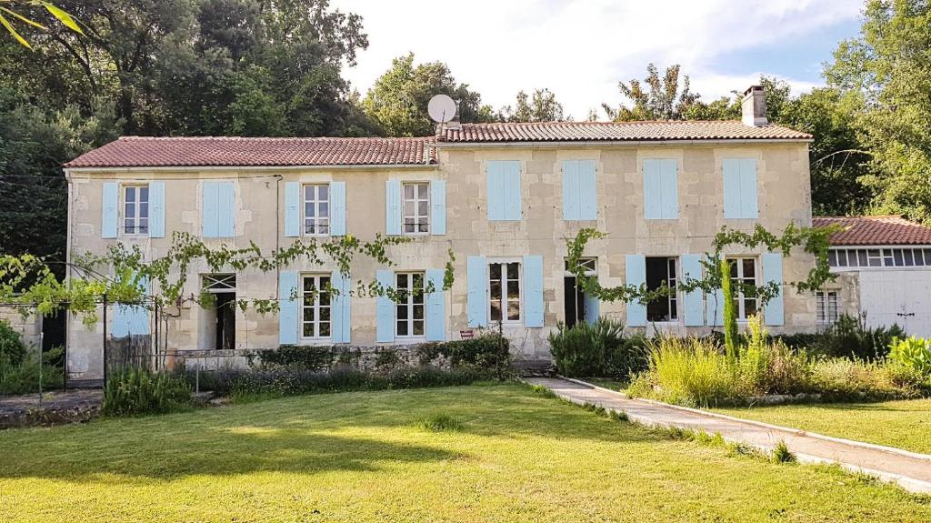 an old house with a garden in front of it at ENTRE PIERRE ET BOIS in Saint-Savinien