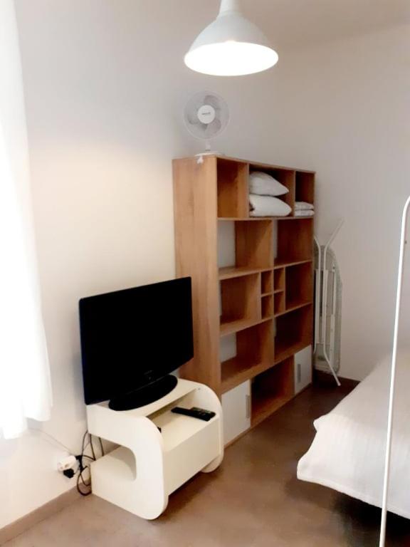 monitor komputerowy siedzący na białym stojaku w pokoju w obiekcie Magnificent apartment in the center of Prague w Pradze