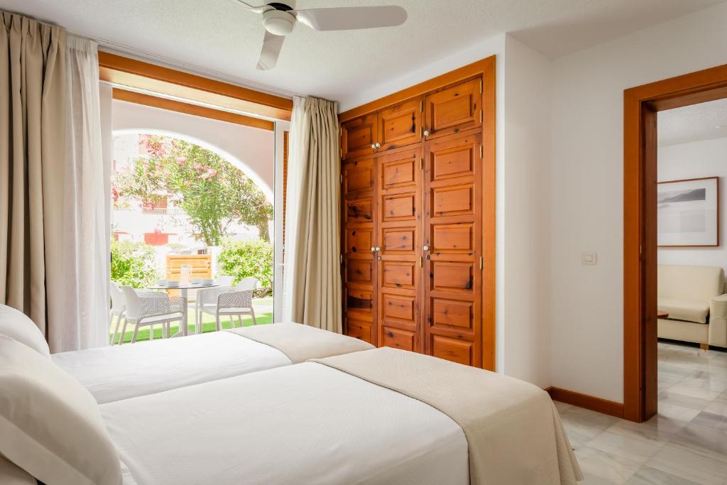 a bedroom with a bed and a large window at Parque Santiago III Official in Playa de las Americas