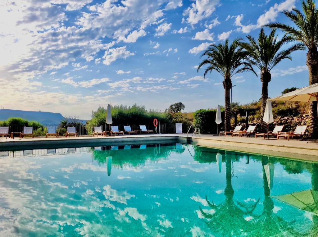 basen z palmami i krzesłami w obiekcie Real Agua Amarga La Joya - Adults Only w mieście Agua Amarga