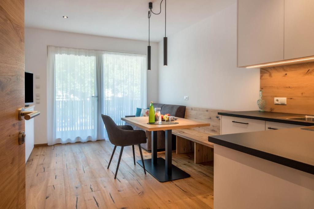eine Küche mit einem Tisch und Stühlen im Zimmer in der Unterkunft Luisl Hof - Apartment Vitis in Girlan