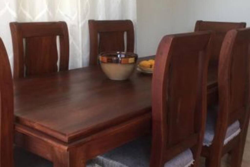a wooden table with two chairs and a bowl on it at Apartamento JM. in San Felipe de Puerto Plata