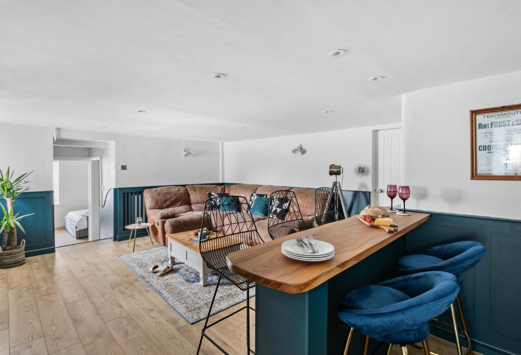 uma sala de estar com uma mesa e um sofá em Coombe Bank - Seaboard spirit, contemporary chic with parking close to beach em Teignmouth