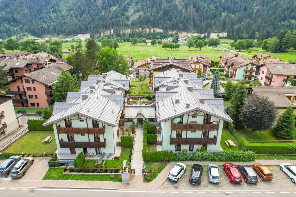 an aerial view of a house with cars parked in a parking lot at Residence Rta La Rosa delle Dolomiti in Carisolo