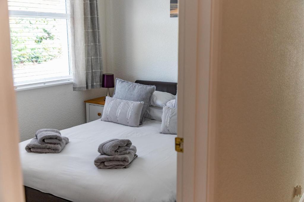 a bedroom with a bed with towels on it at 2 Chatsworth Riverscape Apartments - Peaceful apartment in great location with free parking overlooking the Gannel just a short walk from Newquays incredible beaches and local amenities in Newquay