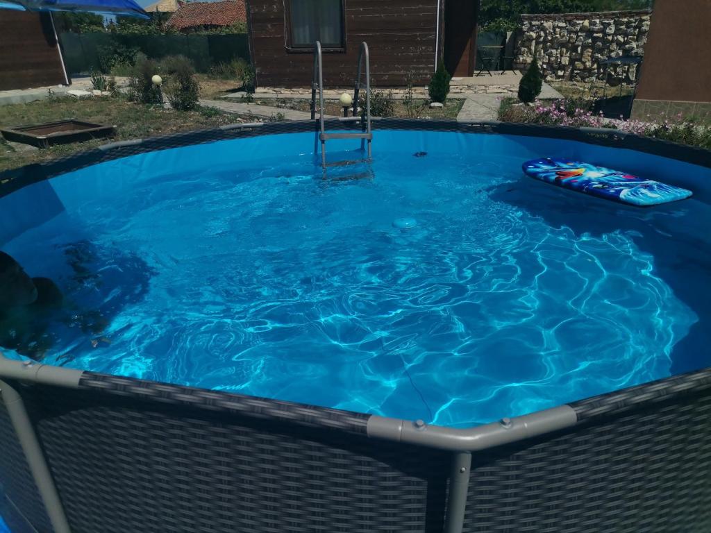una gran piscina azul con una silla alrededor en Бунгало парк Summer Life en Tyulenovo
