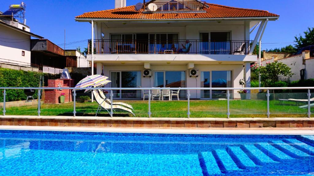 una casa con piscina frente a una casa en Вила Сънрайз - Villa Sunrise, en Varna