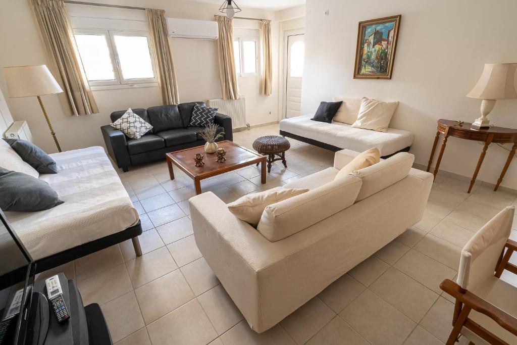 een woonkamer met een bank en een tafel bij Casa d'Arte in Vrahati