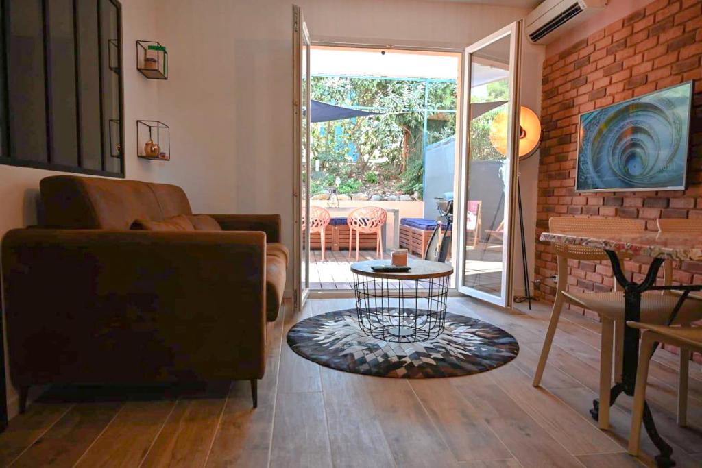 - un salon avec un canapé et une table dans l'établissement Appartement cosy & moderne à 180m de la plage, à Sanary-sur-Mer