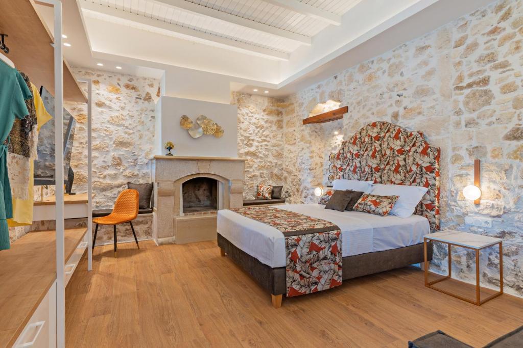 ein Hotelzimmer mit einem Bett und einem Kamin in der Unterkunft Castelvecchio Suites in Rethymno