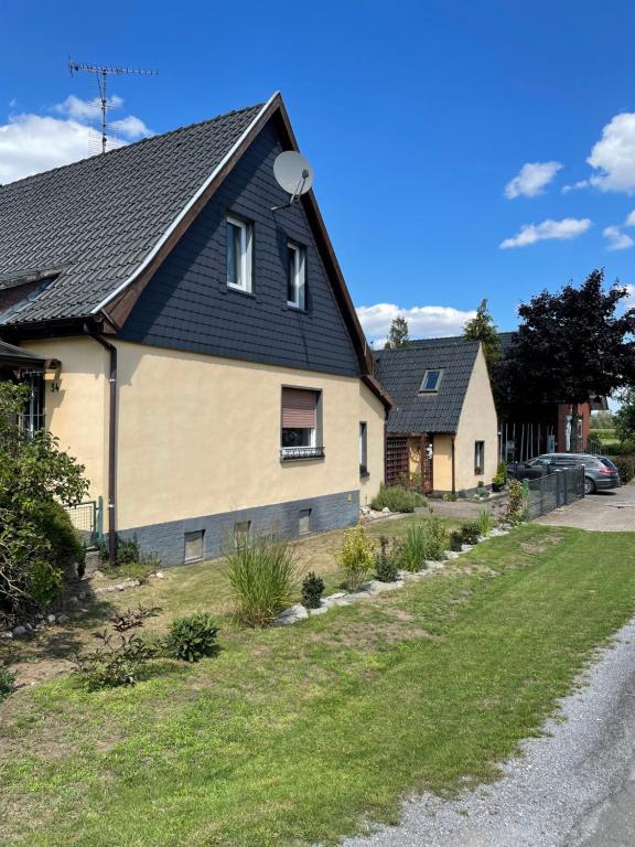 een huis met een zwart dak op een straat bij Siegli's Schlafstube in Petershagen