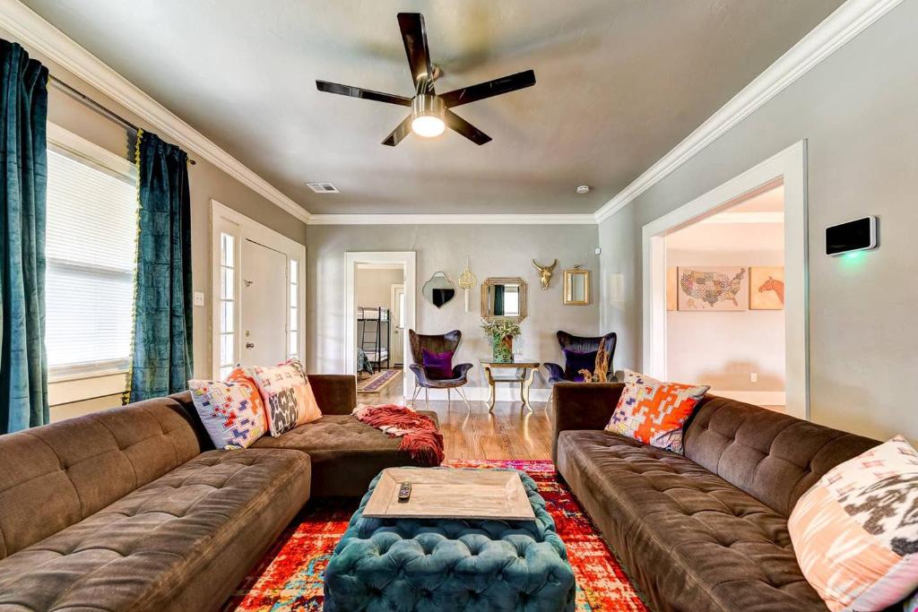 a living room with a couch and a ceiling fan at Boho Bungalow-walk to Plaza District can sleep 8 in Oklahoma City