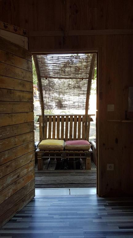 a bench sitting on a porch in a cabin at Echappée sauvage in Masquières