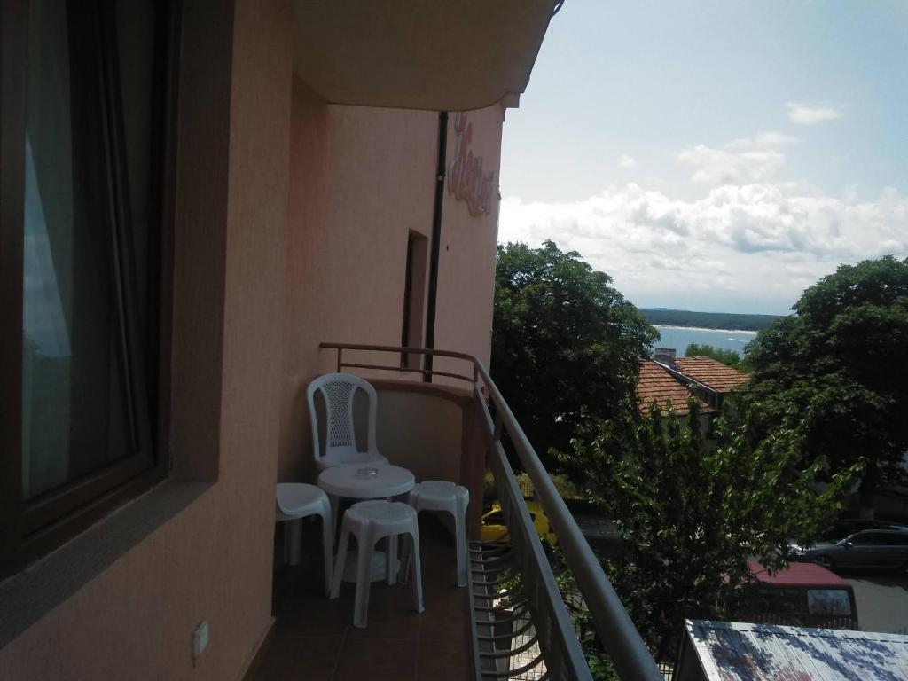 a balcony with two white chairs and a view of the water at Kostovi Primorsko in Primorsko