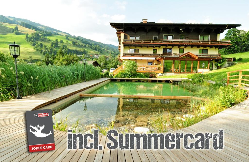 ein Haus mit einem Pool vor einem Haus in der Unterkunft Ski in Ski out Hotel Unterellmau in Saalbach-Hinterglemm