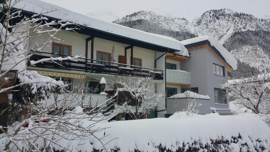 a building covered in snow in front of a mountain at Haus Walch in Pettneu am Arlberg