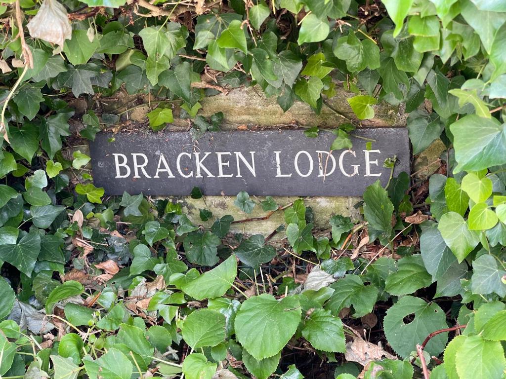 a sign that says bracken lodge in a bush at Bracken Lodge in Brighouse