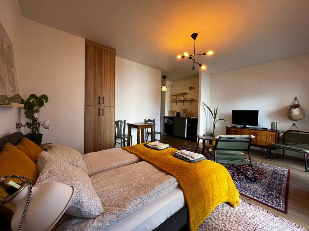 ヴロツワフにあるDmowskiego 13 Tectum Apartmentsのリビングルーム(黄色の毛布付きのベッド付)