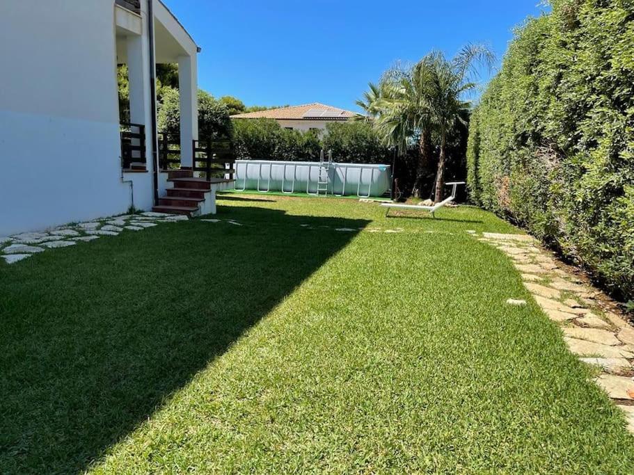 une cour avec de l'herbe verte à côté d'une maison dans l'établissement Villa Jari, à Carini